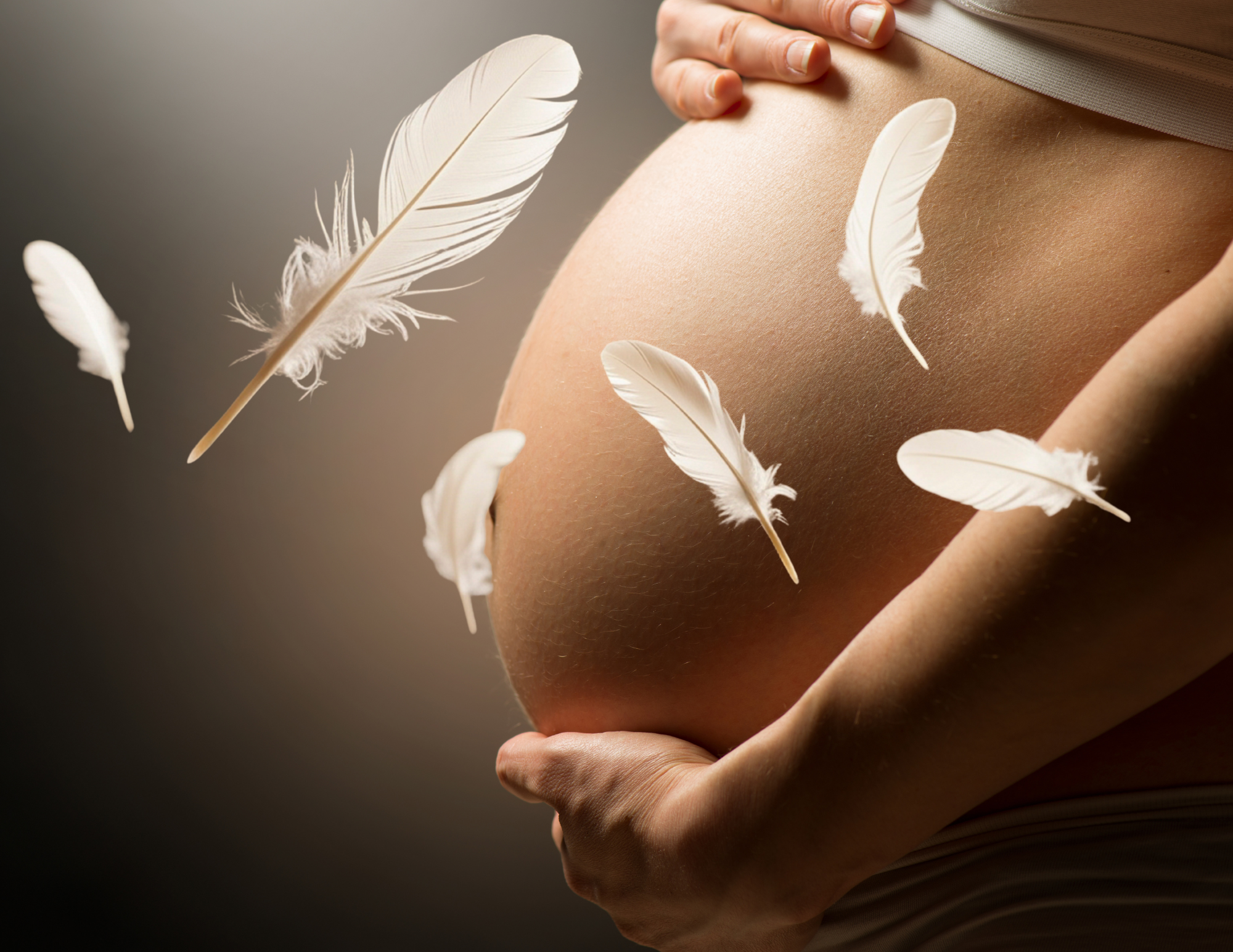 Babybauch mit sanft aufliegenden Federn – Symbol für Ruhe und Entspannung bei einer Schwangerenmassage in Berlin